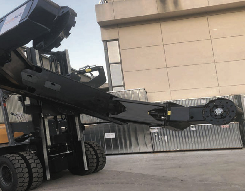 Truck-mounted OTR tyre handler with its manipulator boom extended and the rim mounting plate fitted